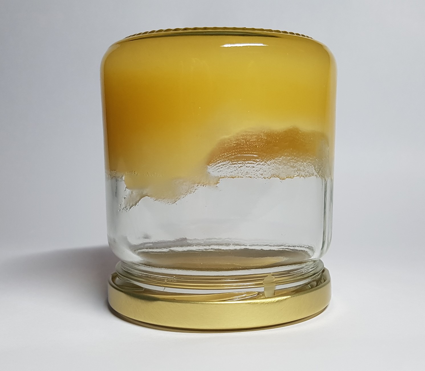 Ein Glas mit kristallisiertem Honig.
